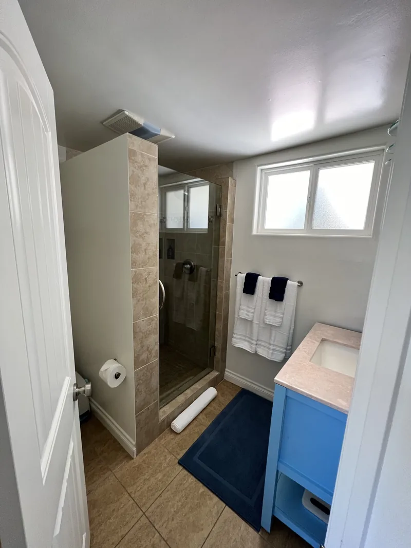 Bathroom with a glass walk-in shower and a pale blue vanity