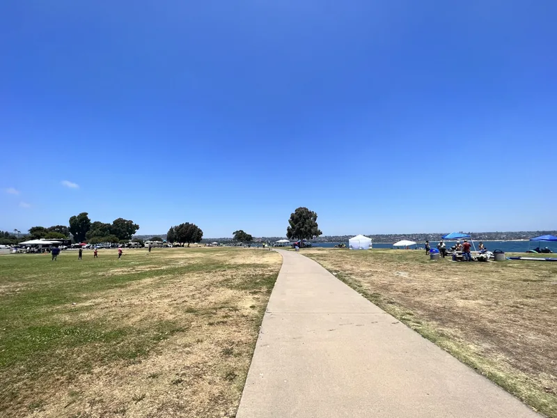 Paved walking and cycling path running between the grass and the water at Mission Bay