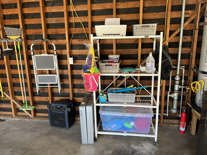 Garage shelving stocked with beach toys, buckets, nets, a wagon and storage bins