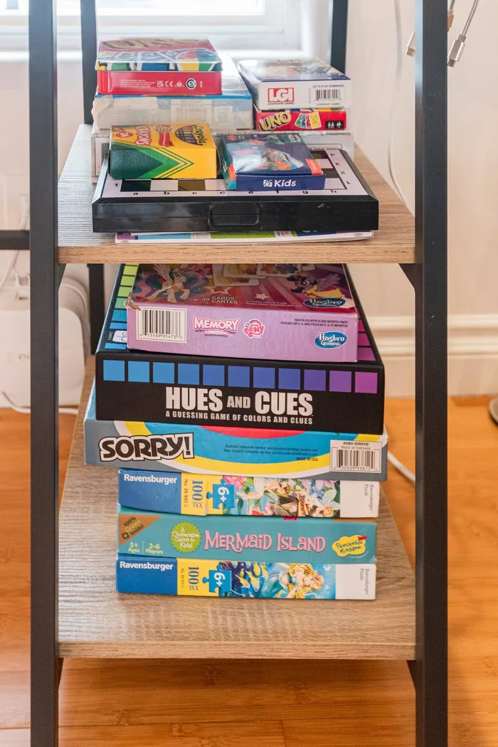 Shelf of family board games including Sorry, Hues and Cues and Mermaid Island