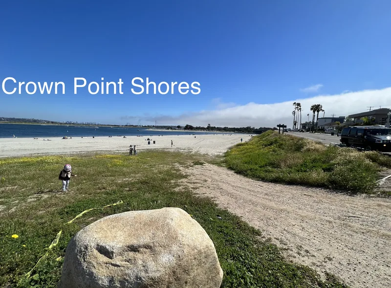 Crown Point Shores park and beach with a large boulder in the foreground and the bay beyond