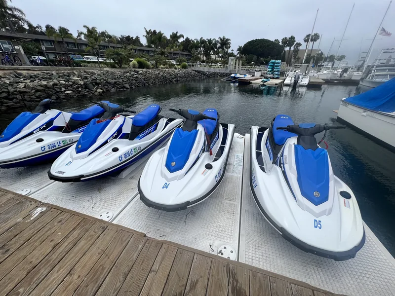 A row of jet skis moored at a dock on Mission Bay, available to rent nearby