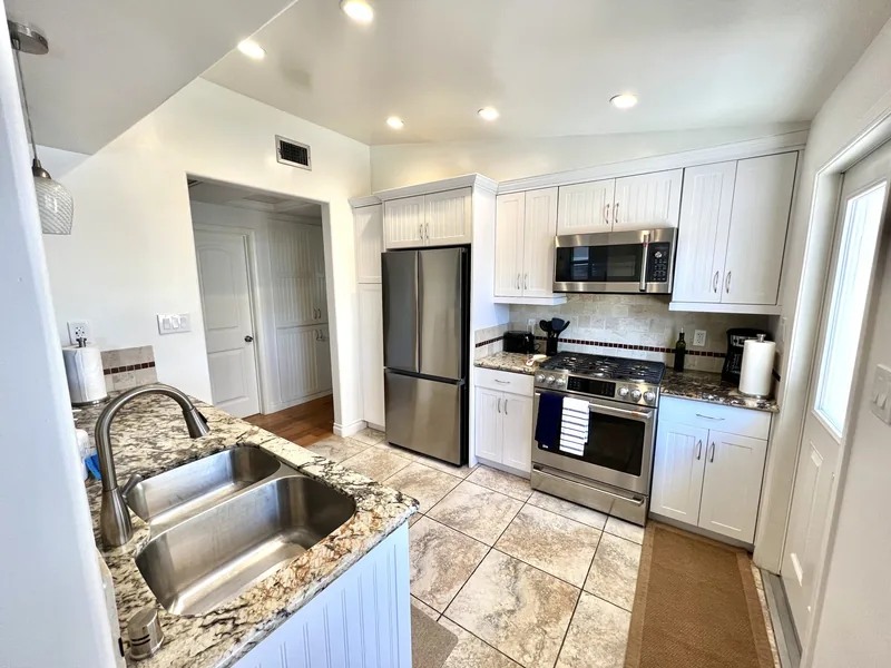 Kitchen with white shaker cabinets, granite counters, stainless gas range, microwave and French-door refrigerator