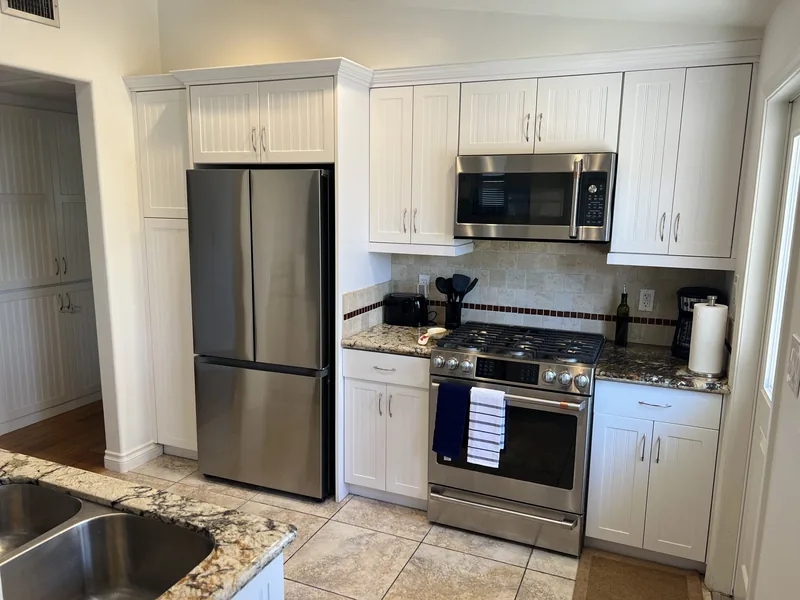 Kitchen at Crown Point Jewell with a stainless French-door refrigerator, gas range with oven, microwave above, and granite counters