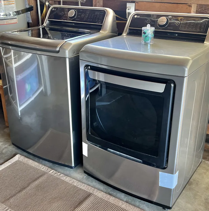 Full-size stainless washer and dryer side by side in the garage