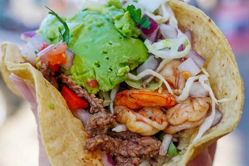 A taco piled with shrimp, carne asada, guacamole, cabbage and pico de gallo from Oscar’s Mexican Seafood