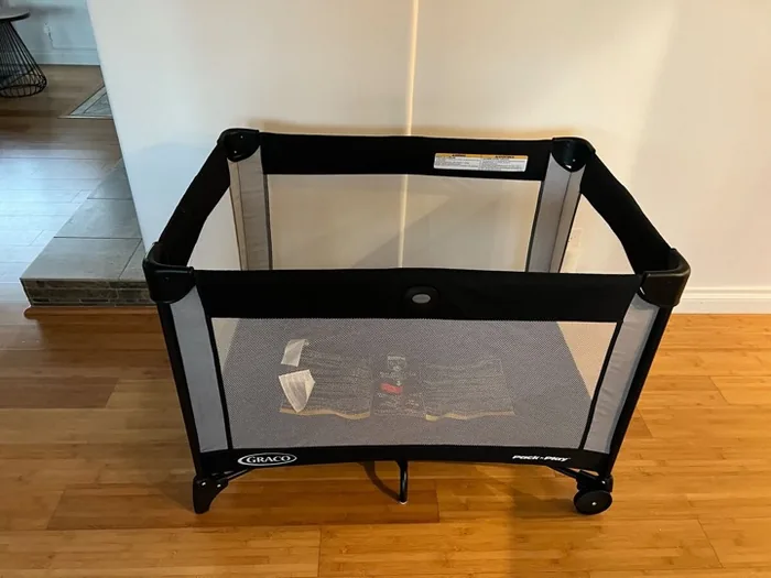 Graco Pack 'n Play portable travel crib set up on the hardwood floor