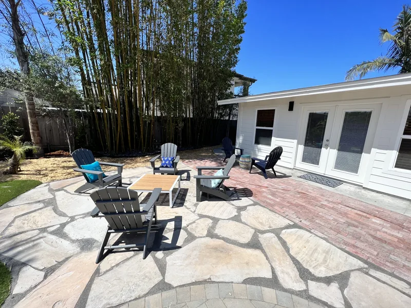Backyard patio seating around the fire pit, with the house and French doors behind