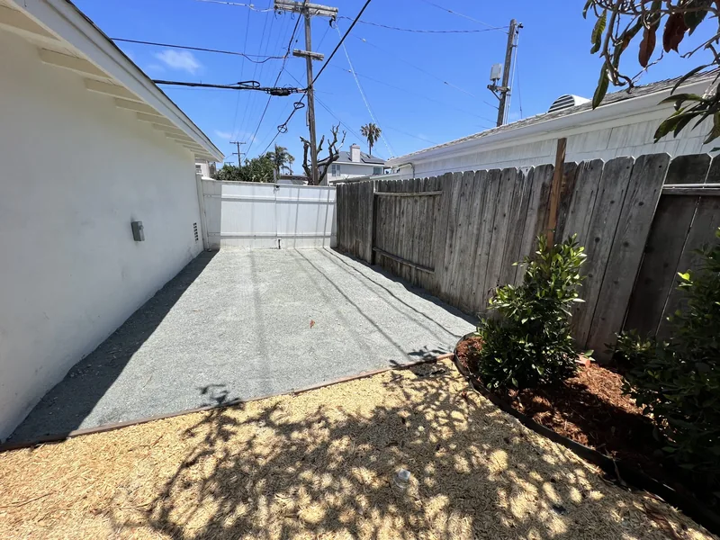 Paved side yard walkway running alongside the house to the backyard gate