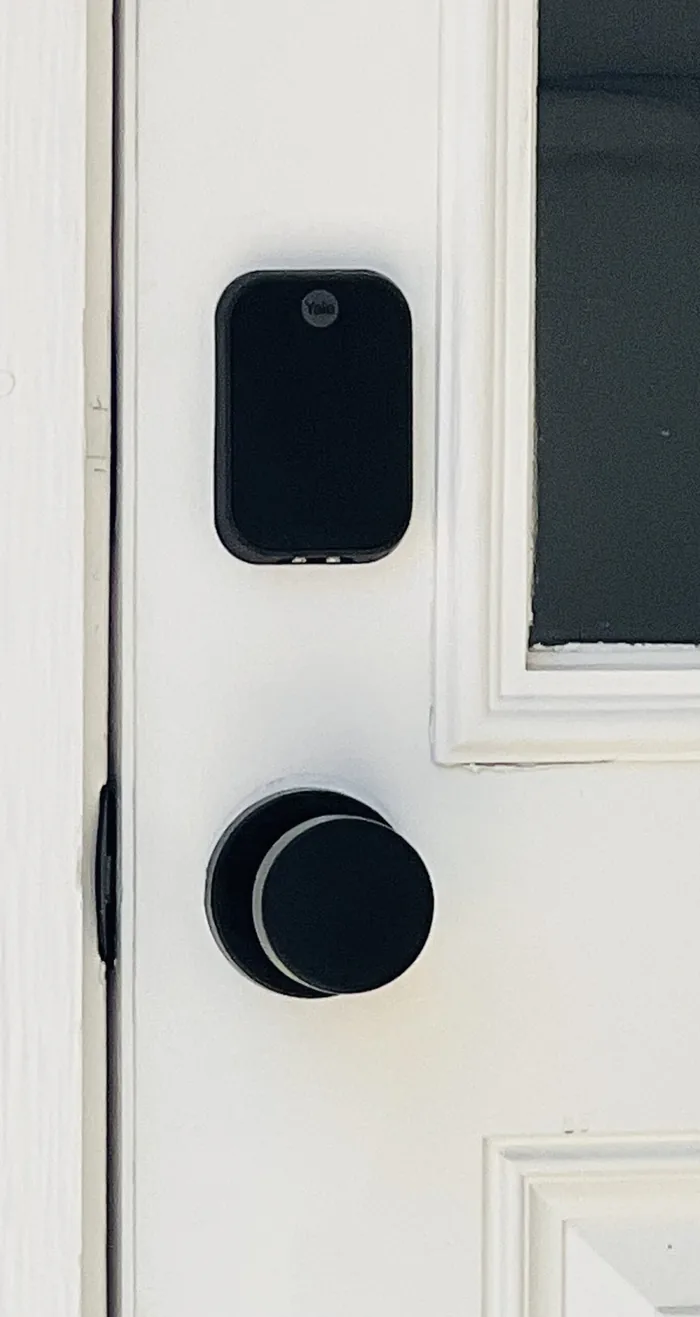 Keyless smart lock and black handle on the white front door